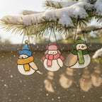 Blue and pink stained glass birds on a branch – winter holiday suncatcher decoration.