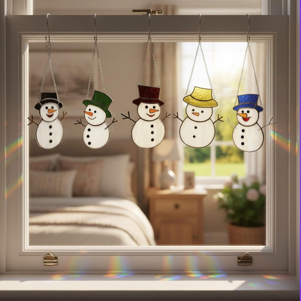 Winter home decor featuring stained glass snowman ornaments glowing on window.