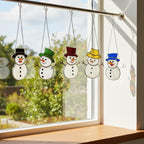 Handcrafted snowman suncatcher catching light beautifully in cozy living room.