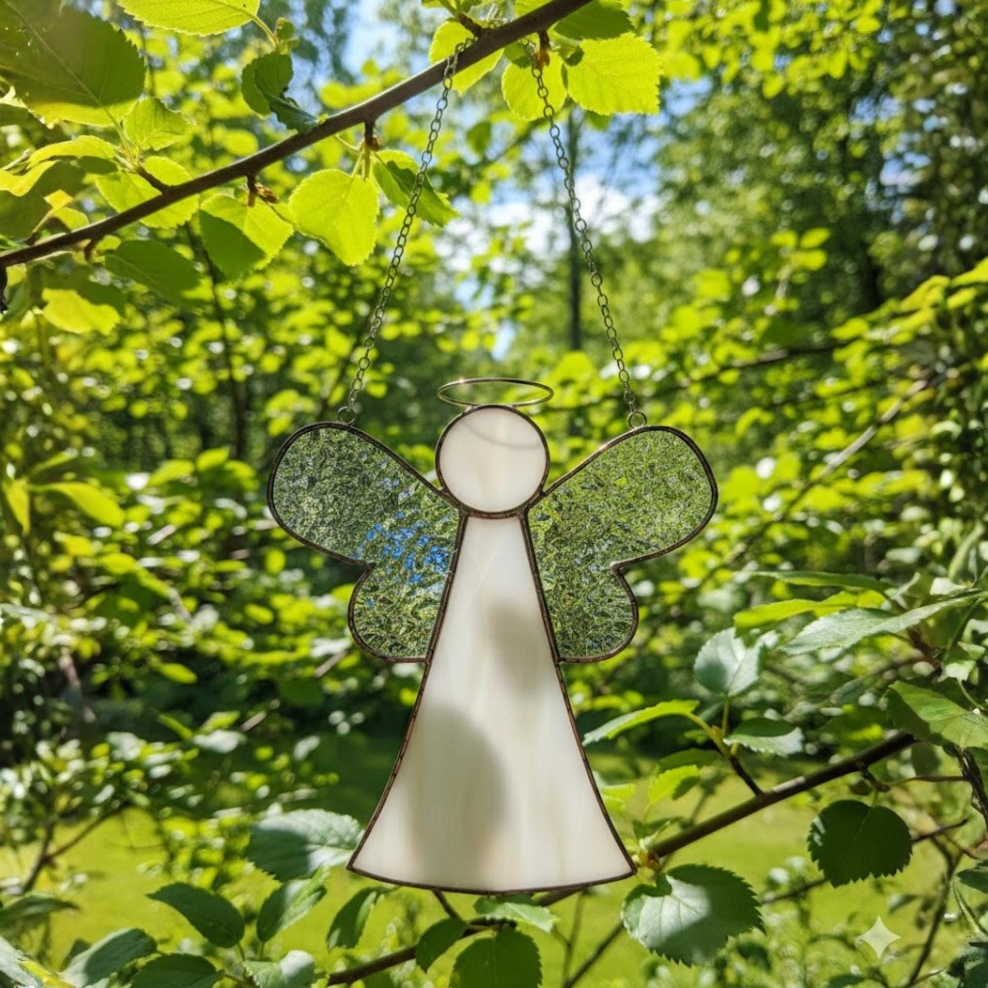 Memorial glass angel ornament symbolizing love and remembrance by a sunny window.