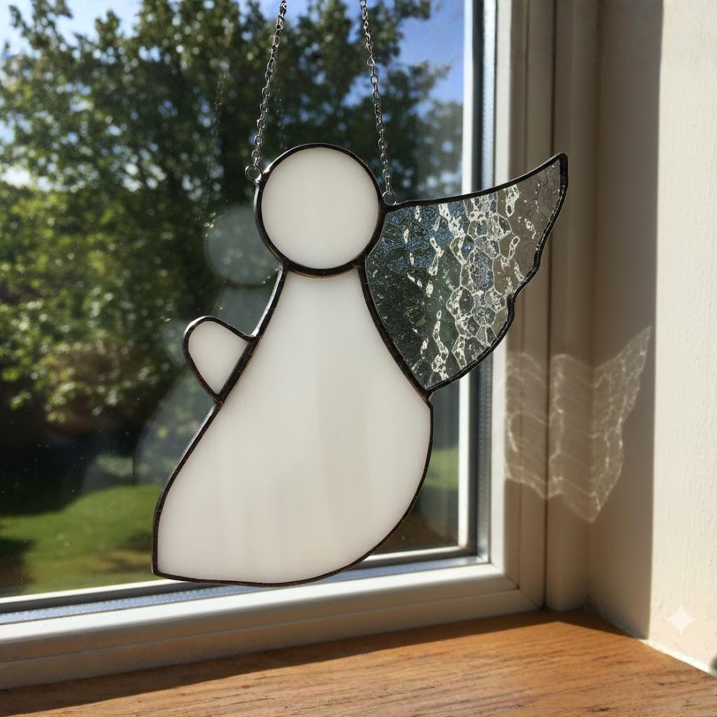 Couple holding stained glass angel suncatcher gift near a bright window.