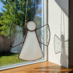 Peaceful handmade angel displayed near green garden view, perfect home accent.