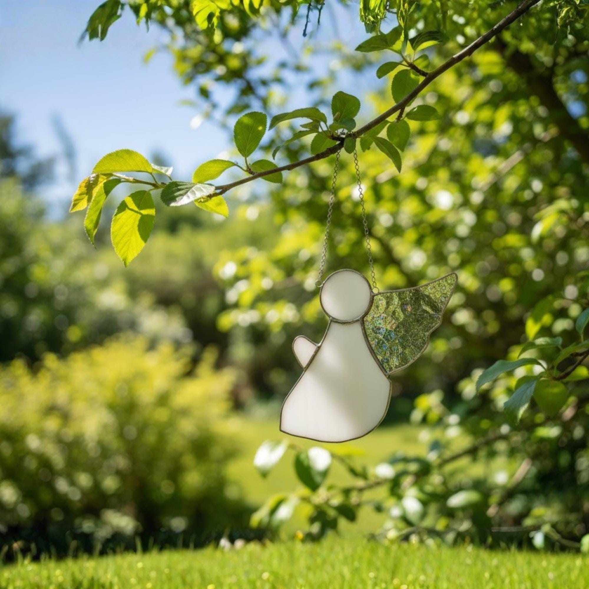 Clear glass angel with frosted wings sparkling in daylight as unique spiritual decor.