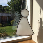 Handmade stained glass angel window decor representing protection and serenity.