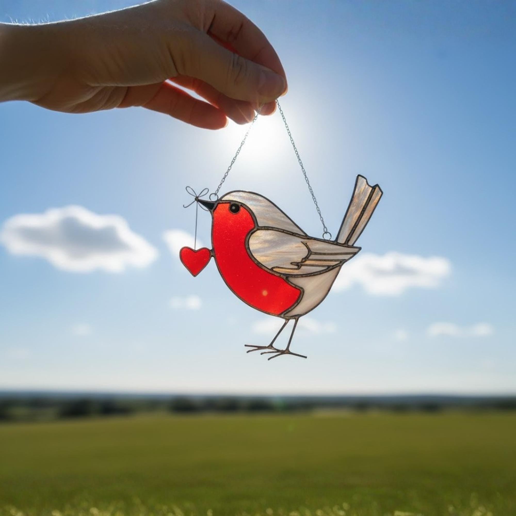 Woman decorating window with robin stained glass, cozy winter home decor idea