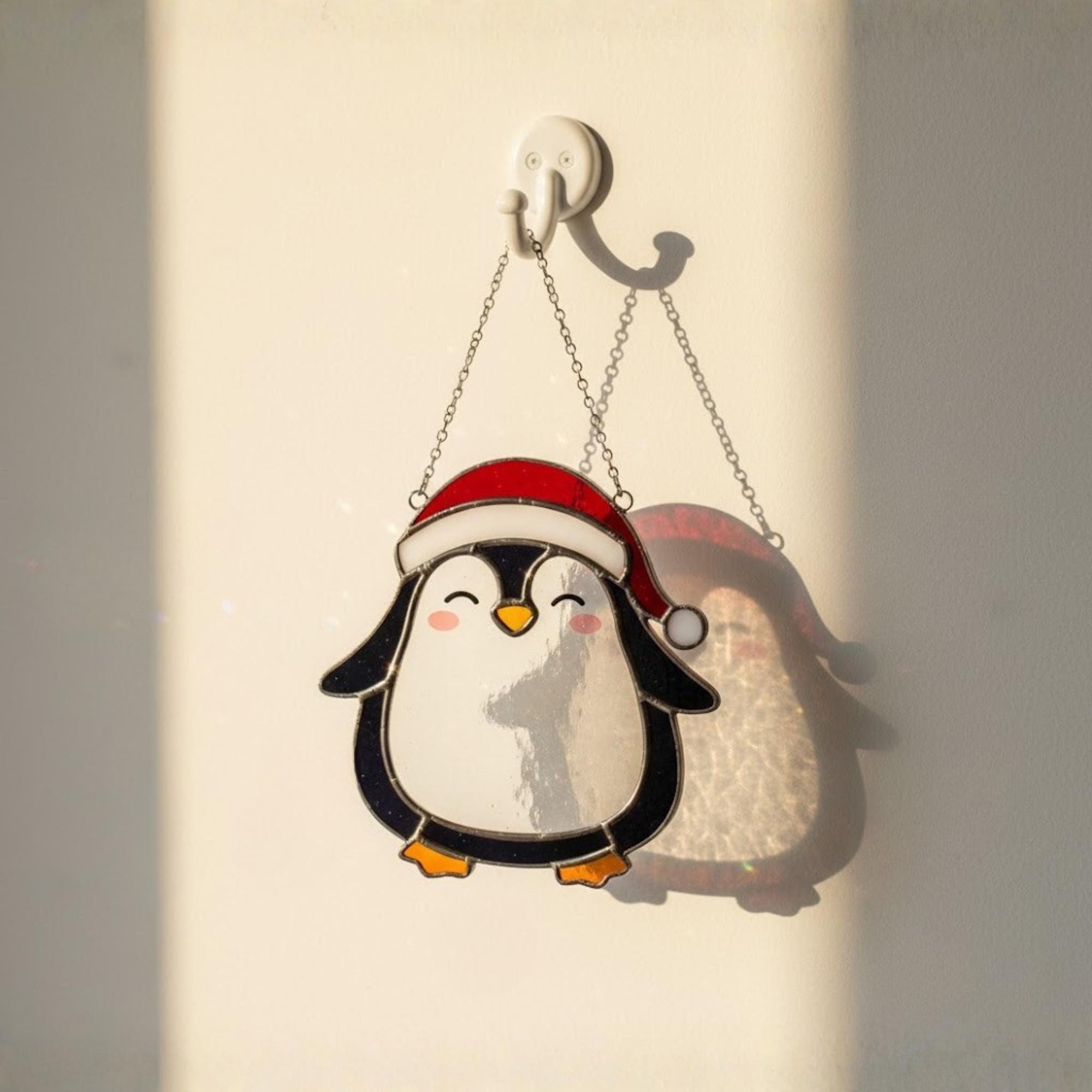 Two penguin ornaments among lights on Christmas tree, festive decoration