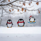 Row of penguin suncatchers across large window, bright winter home decoration
