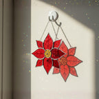 Red poinsettia stained glass ornament close up, handmade Christmas décor