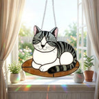 Stained glass cat suncatcher capturing sunlight on window sill, bright window decor.