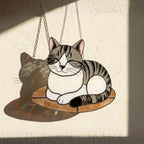 Close up of stained glass cat casting a clear shadow on the wall, suncatcher light effect.