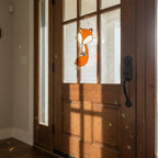 Stained glass fox ornament glowing on glass door, handmade animal decor