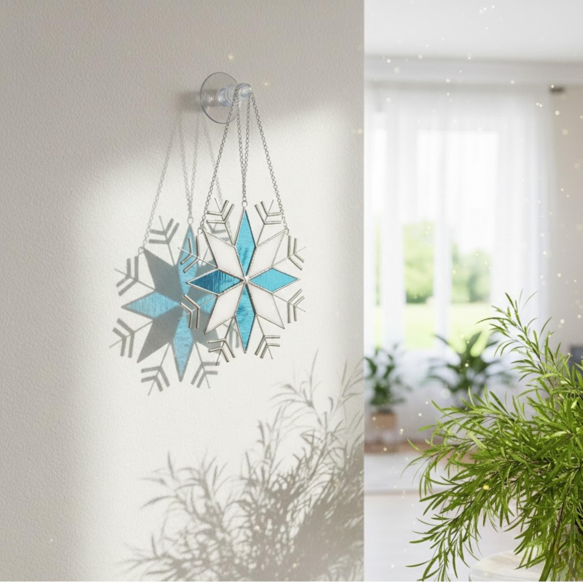 Handmade stained glass snowflake suncatcher glowing in window light, winter home decor