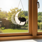 Cat moon suncatcher hanging outside near garden, whimsical outdoor decor