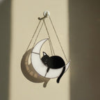 Stained glass moon cat glowing on window sill at sunset, celestial home decor