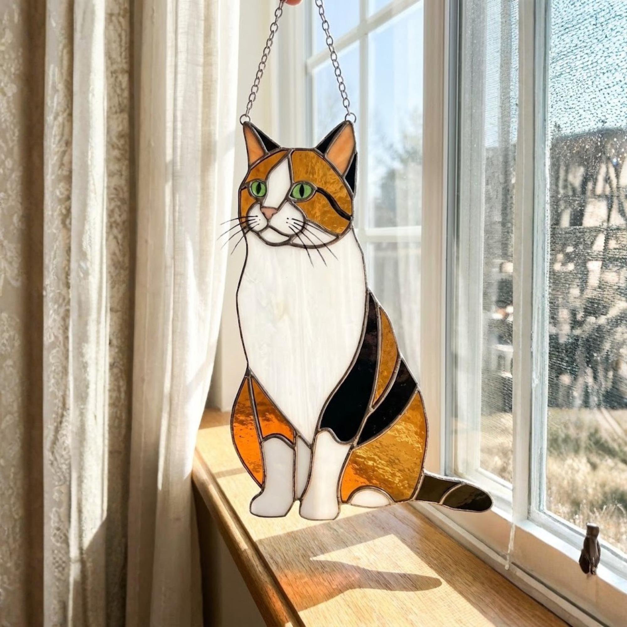 Stained glass Calico cat suncatcher with orange black and white patches, available in sitting and sleeping poses, window hanging or wood stand decor.