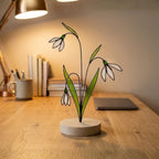 Stained glass snowdrop flower with white petals and green leaves, January birth month gift, available with personalized wood stand or as a single stem.