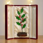 Stained glass holly plant inside a luxury red gift box, secure packaging for Christmas gift.