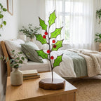 Stained glass holly branch with red berries on wooden base, cozy bedroom decor, Christmas table centerpiece.