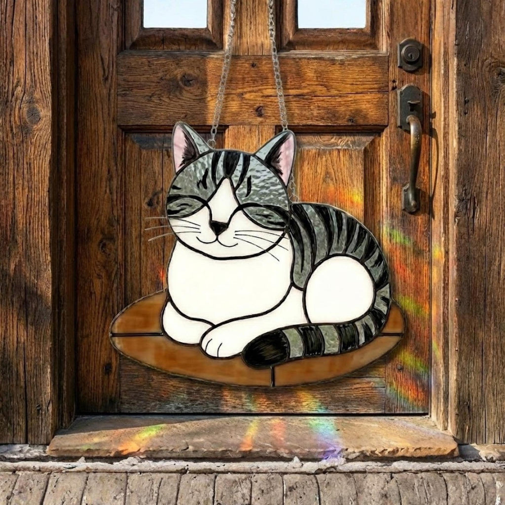 Grey tabby cat ornament hanging on rustic wooden door, farmhouse style decoration. 1