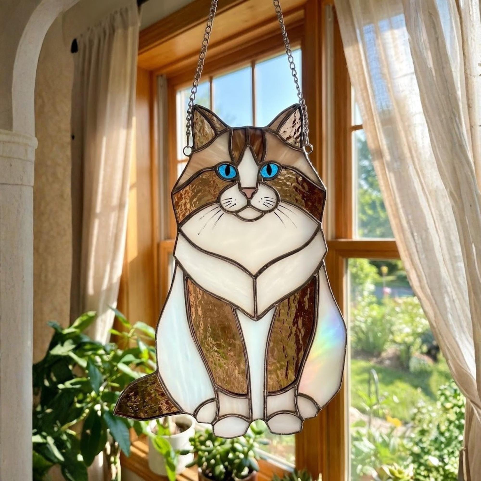 Brown and white Ragdoll cat stained glass suncatcher with blue eyes.