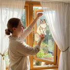 Woman hanging a fluffy Ragdoll cat suncatcher on sunny window, home decor idea.