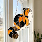 Stained glass Calico cat suncatcher with orange black and white patches, available in sitting and sleeping poses, window hanging or wood stand decor.