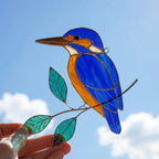 Vibrant stained glass Kingfisher bird suncatcher with blue wings and orange chest perched on a branch, displayed as window hanging or table decor.