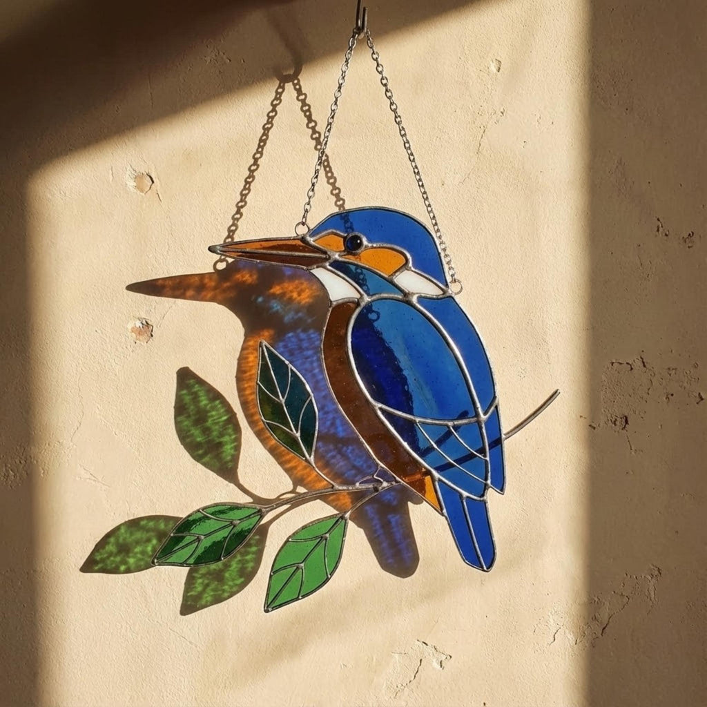 Vibrant stained glass Kingfisher bird suncatcher with blue wings and orange chest perched on a branch, displayed as window hanging or table decor.