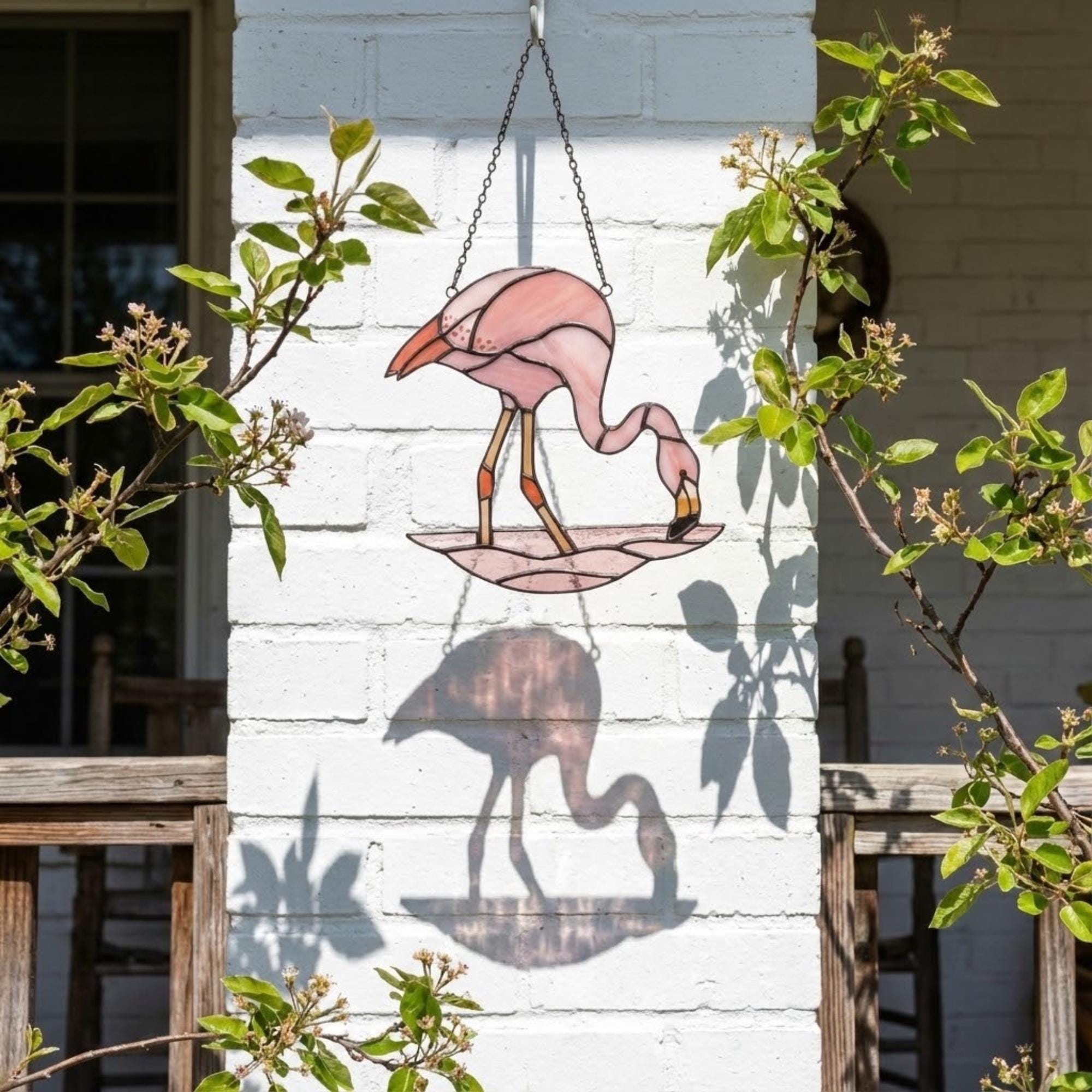 Pink stained glass flamingo suncatcher hanging in window casting vibrant colored shadows tropical beach house decor handmade gift for mom by LuzyGlassArt.