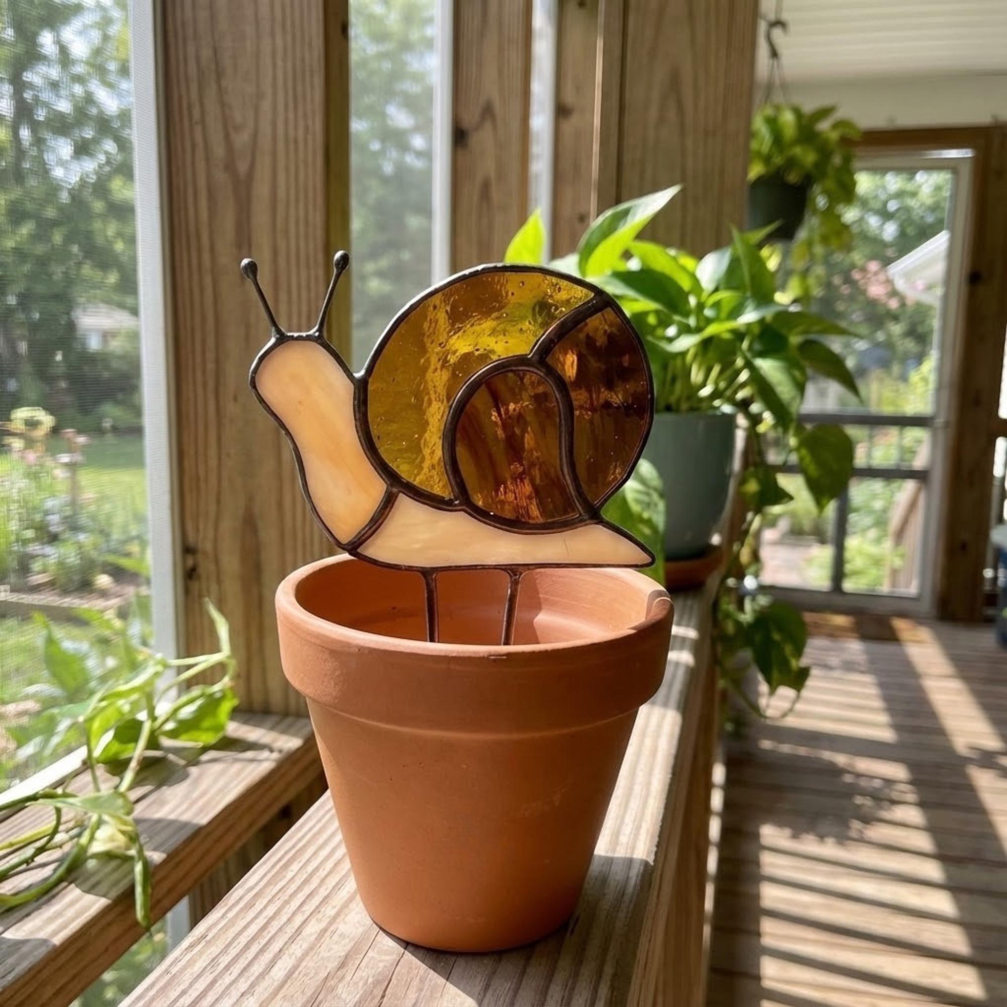 Cute stained glass snail suncatcher hanging on window, whimsical cottagecore decor for plant lovers, colorful glass animal art handmade in Vietnam, goblincore aesthetic gift.
