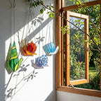 Cute stained glass snail suncatcher hanging on window, whimsical cottagecore decor for plant lovers, colorful glass animal art handmade in Vietnam, goblincore aesthetic gift.