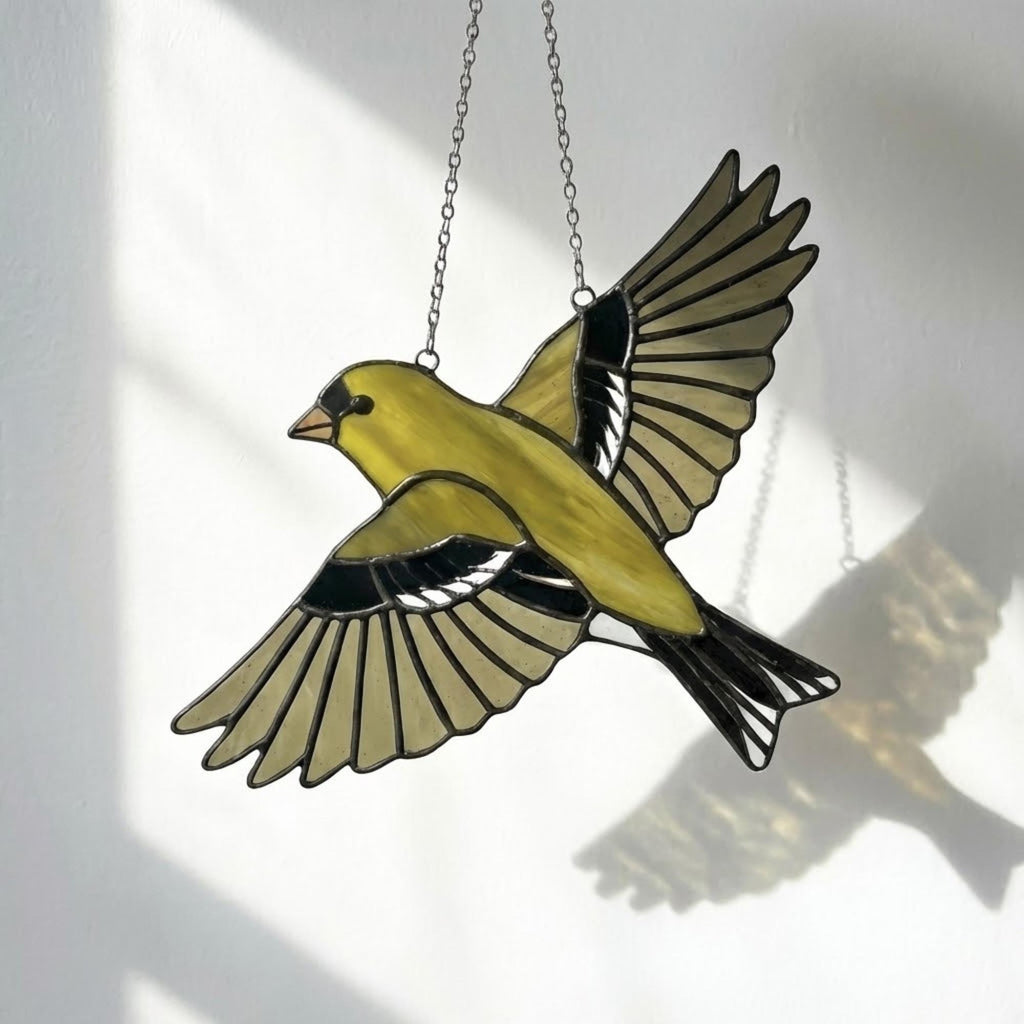 Stained glass American Goldfinch suncatcher hanging on window casting yellow shadows, vibrant yellow bird ornament for birdwatchers, handmade state bird gift for New Jersey Iowa Washington by LuzyGlassArt.