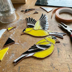 Stained glass American Goldfinch suncatcher hanging on window casting yellow shadows, vibrant yellow bird ornament for birdwatchers, handmade state bird gift for New Jersey Iowa Washington by LuzyGlassArt.