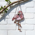 Pink stained glass flamingo suncatcher hanging in window casting vibrant colored shadows tropical beach house decor handmade gift for mom by LuzyGlassArt.