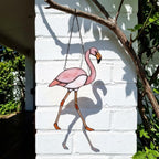 Pink stained glass flamingo suncatcher hanging in window casting vibrant colored shadows tropical beach house decor handmade gift for mom by LuzyGlassArt.