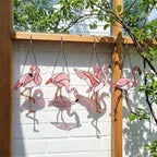 Pink stained glass flamingo suncatcher hanging in window casting vibrant colored shadows tropical beach house decor handmade gift for mom by LuzyGlassArt.