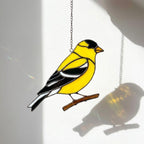 Stained glass American Goldfinch suncatcher hanging on window casting yellow shadows, vibrant yellow bird ornament for birdwatchers, handmade state bird gift for New Jersey Iowa Washington by LuzyGlassArt.