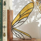 Handmade dragonfly wing stained glass bookends on premium solid oak base, green and yellow glass casting shadows, art nouveau luxury decor.