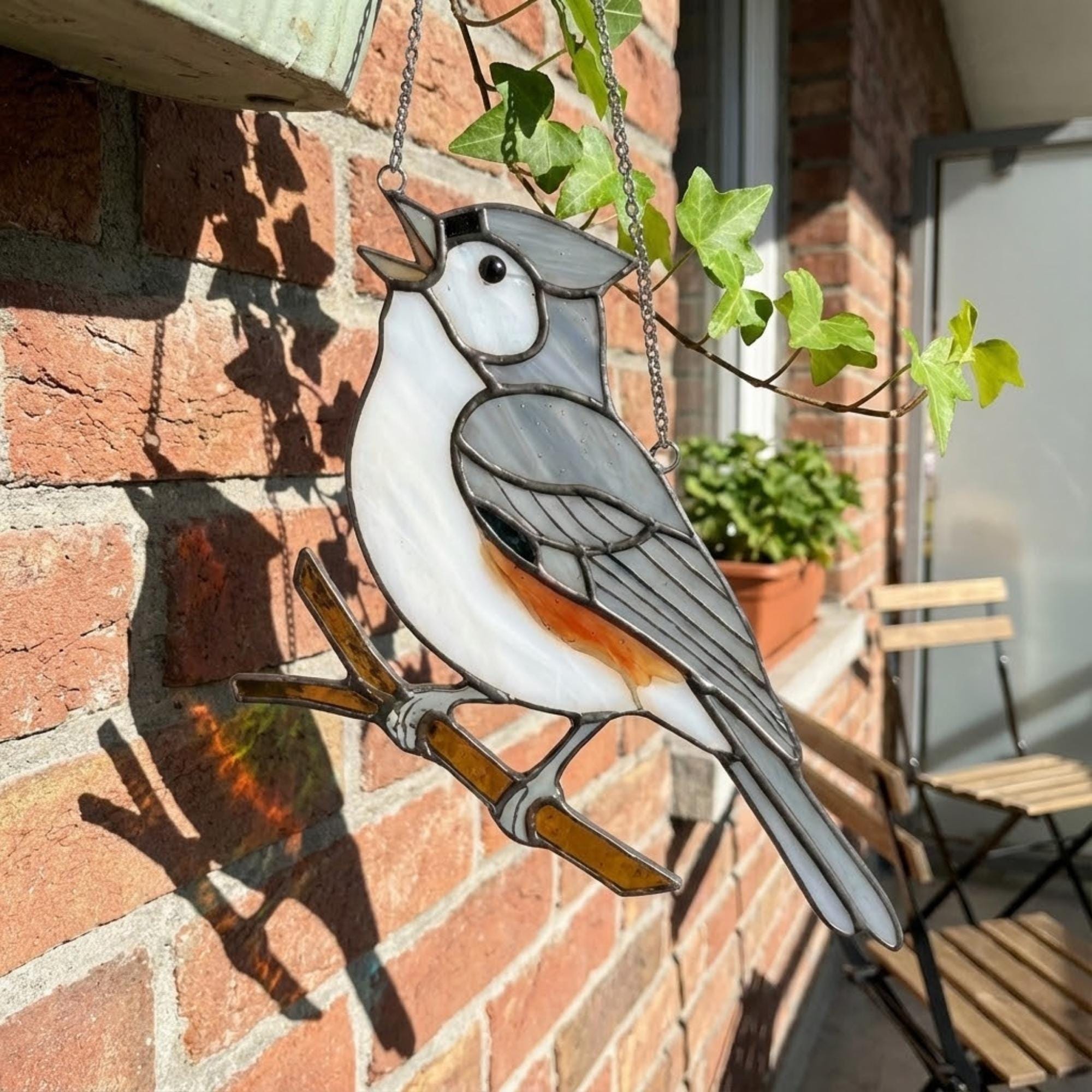 Stained glass Black-capped Chickadee bird suncatcher on branch hanging on window, handmade Maine and Massachusetts state bird gift, realistic nature decor by LuzyGlassArt.