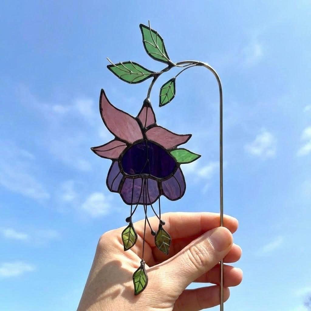 Handmade stained glass plant stakes collection including hummingbird, cardinal, blue jay birds, monarch butterfly, dragonfly, and flowers attached to metal rods for indoor plant pot decoration.
