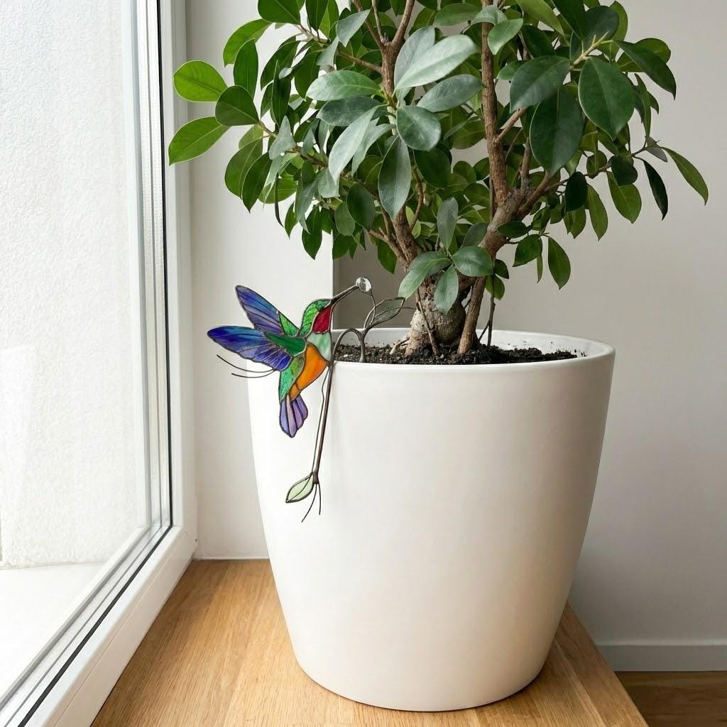 Handmade stained glass snail plant stake with amber shell and green leaves, cute cottagecore garden decor for indoor pots, gift for plant lover.