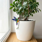 Handmade stained glass snail plant stake with amber shell and green leaves, cute cottagecore garden decor for indoor pots, gift for plant lover.