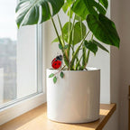 Handmade stained glass snail plant stake with amber shell and green leaves, cute cottagecore garden decor for indoor pots, gift for plant lover.