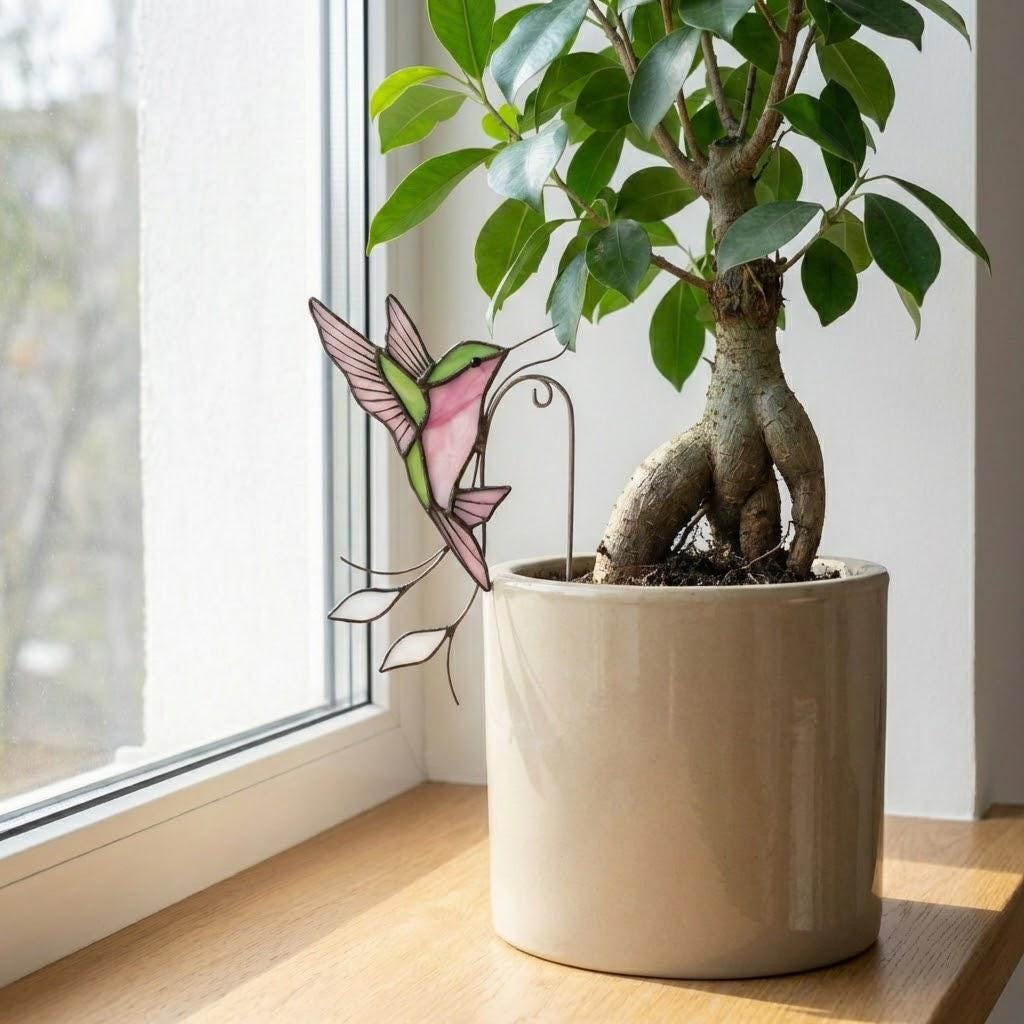 Handmade stained glass snail plant stake with amber shell and green leaves, cute cottagecore garden decor for indoor pots, gift for plant lover.