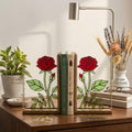 Handmade stained glass red rose flower bookends on solid wood bases casting beautiful colorful shadows, romantic anniversary and book lover gift.