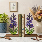 Handmade stained glass purple larkspur flower bookends on premium wood bases casting colorful shadows, beautiful July birth flower botanical shelf decor.