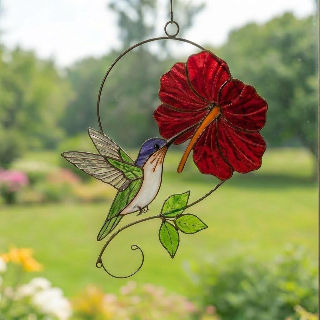 Handmade hummingbird and red hibiscus flower stained glass suncatcher casting vibrant colored shadows, perfect tropical botanical decor and memorial gift for mom.