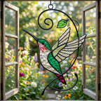 Handcrafted stained glass hummingbird and floral suncatchers in a circular metal hoop, casting colored shadows, packaged in a luxury wooden gift box for Mother's Day.