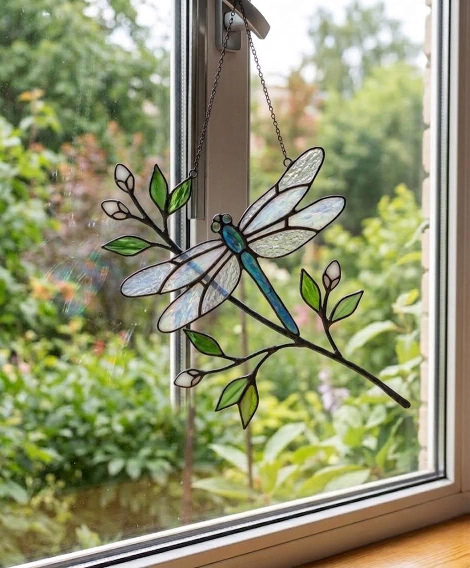 Handcrafted iridescent stained glass dragonfly suncatcher on a branch casting colored shadows, perfect memorial or Mother's Day window decor gift.
