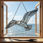 Handcrafted wispy stained glass flying seagull suncatcher casting shadows, perfect coastal beach house decor and nautical ocean lover gift.